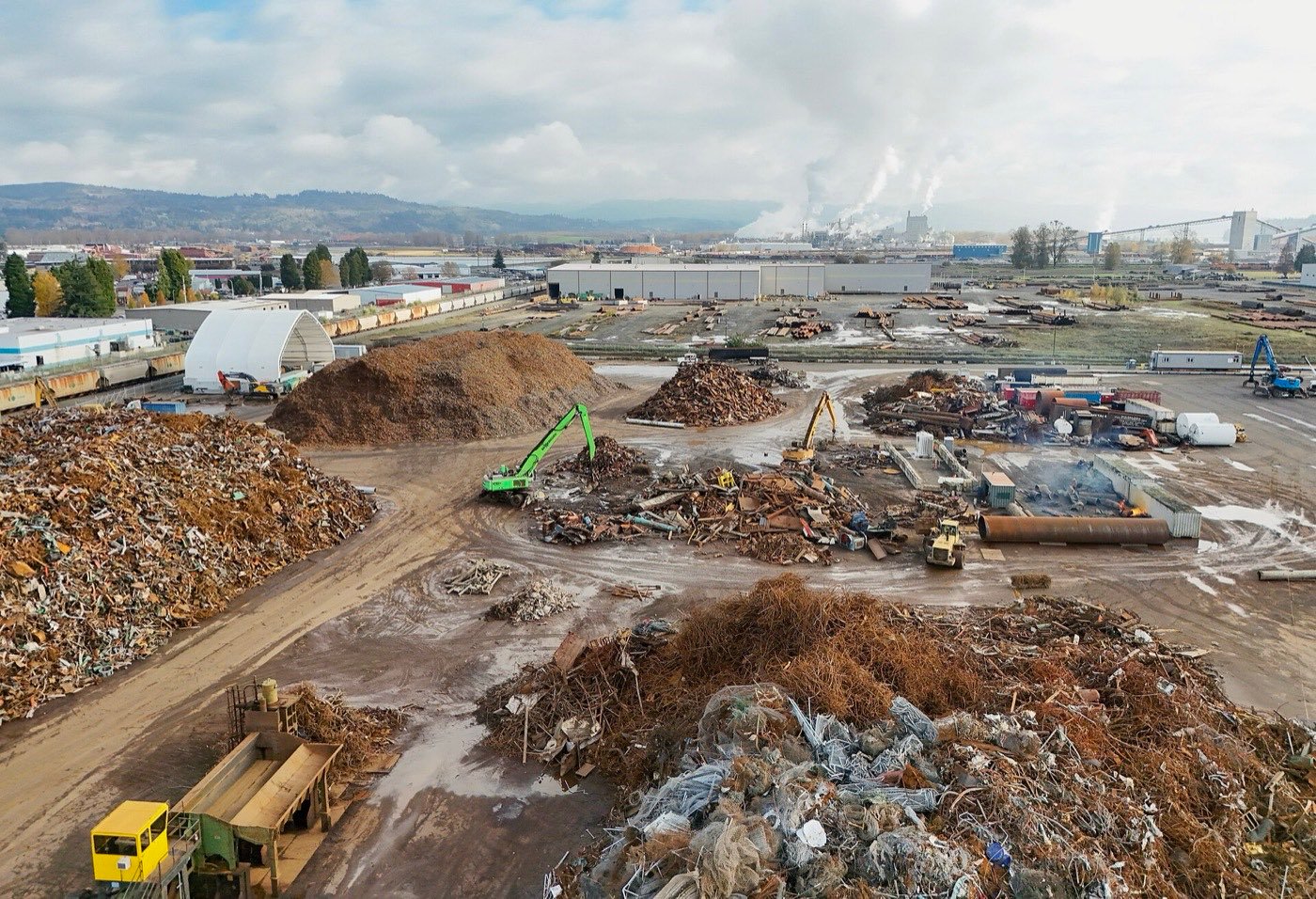 Scrap metal piles and a material handler at a non-ferrous recycling yard