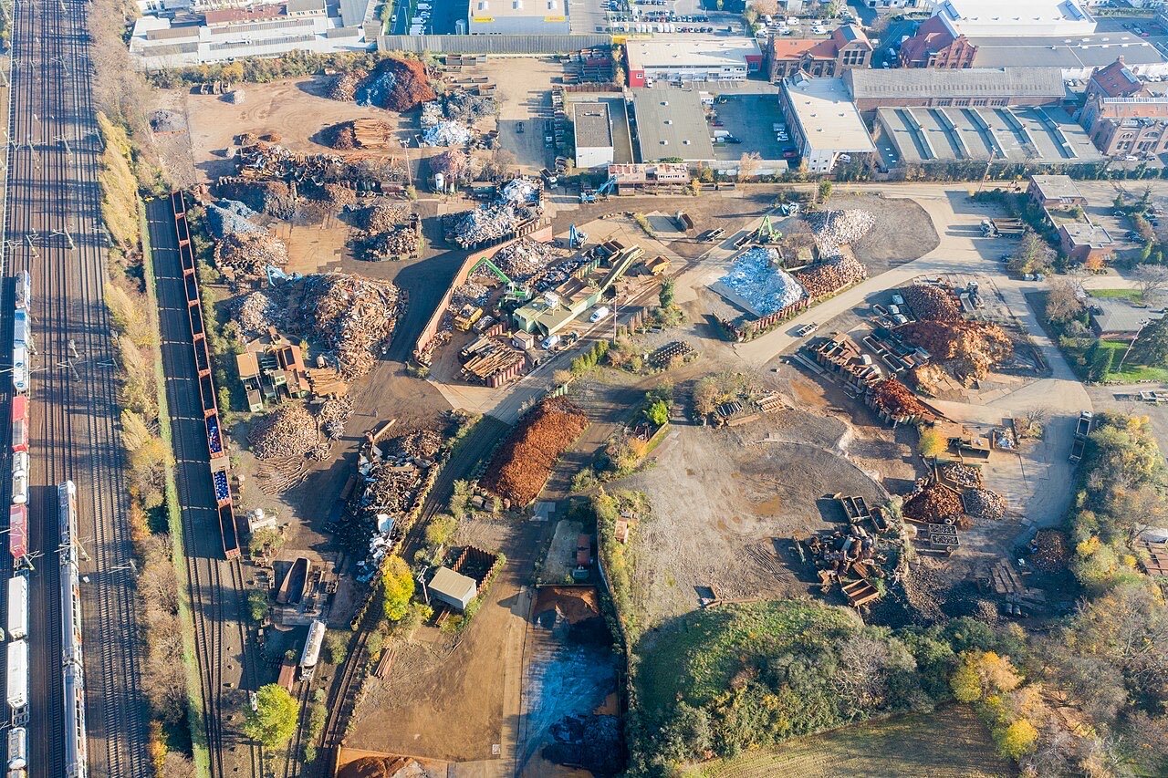 Aerial view of a scrap metal yard beside rail lines